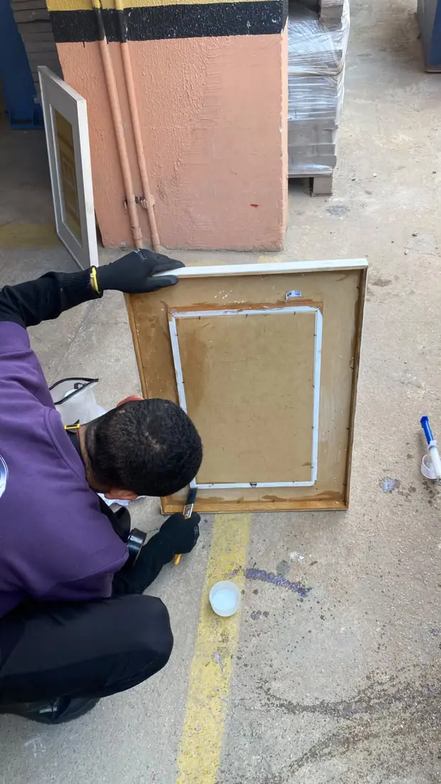 Técnico da D.Lucca aplicando produto contra insetos em moldura de quadro