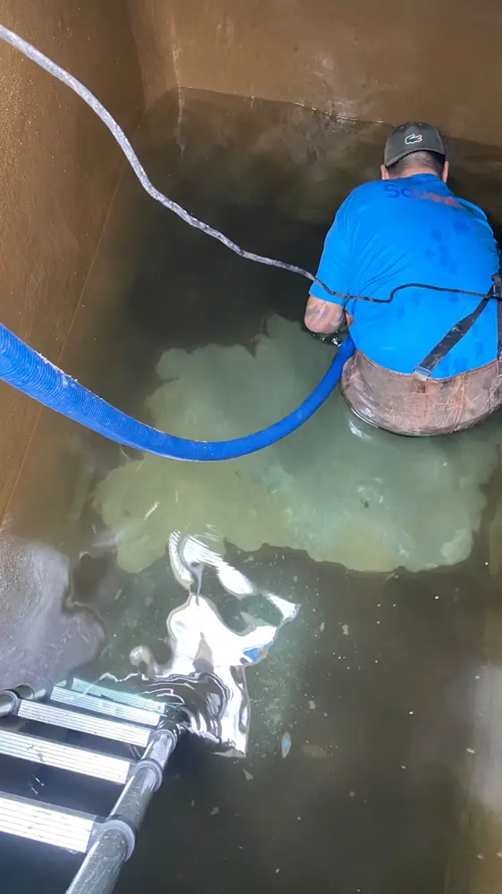 Técnico da D.Lucca realizando limpeza de caixa d'água dentro do reservatório de um condomínio em Florianópolis